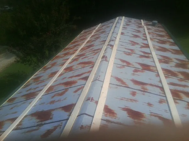Rusted metal roof panels with new wood purlins before replacement — Storm Damage Roof Repair in Ratliff City by Roofing Brothers