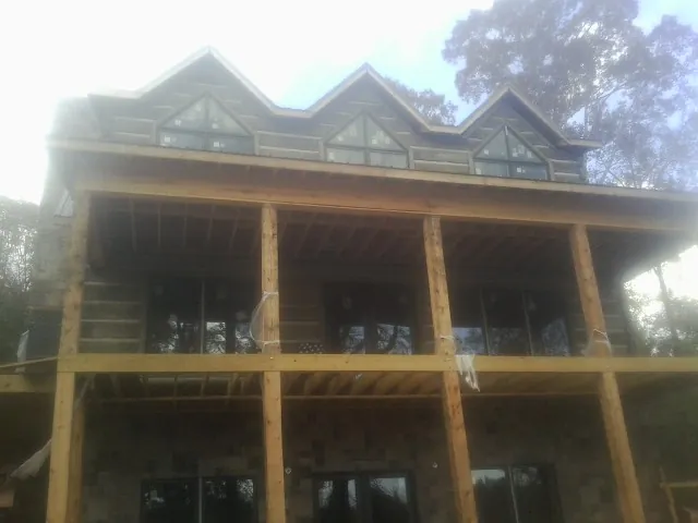 Dormers and porch framing on a large log home under construction — Roof Coating work by our crew in Ratliff City