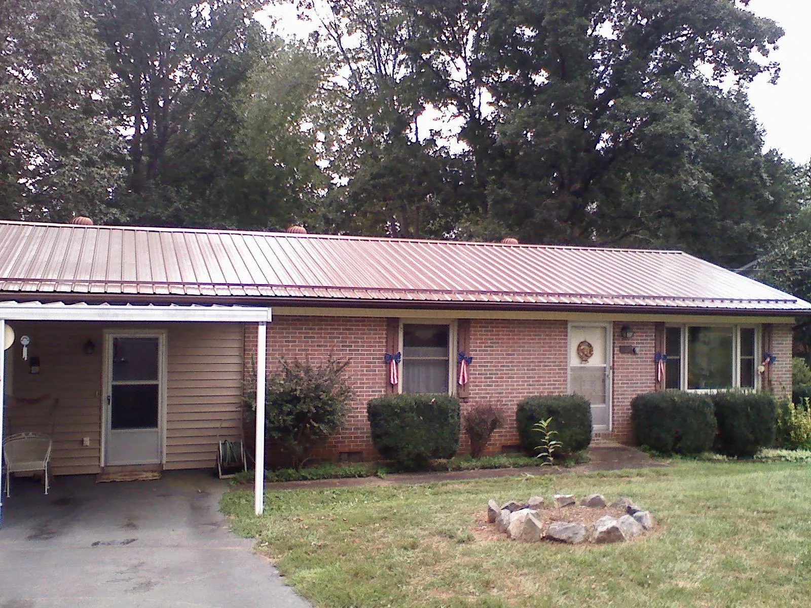 Bronze metal roof and carport on a brick ranch home — Roof Repair work by our crew in Ratliff City