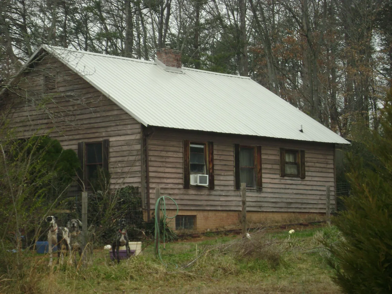 White metal roof on an old wood sided farmhouse, from a Asphalt Shingle Roof Repair job in Ratliff City